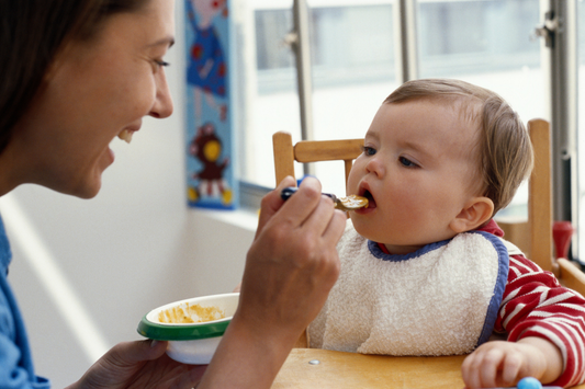 Parent feeding baby peanut puree with a spoon – safe allergen introduction in infants
